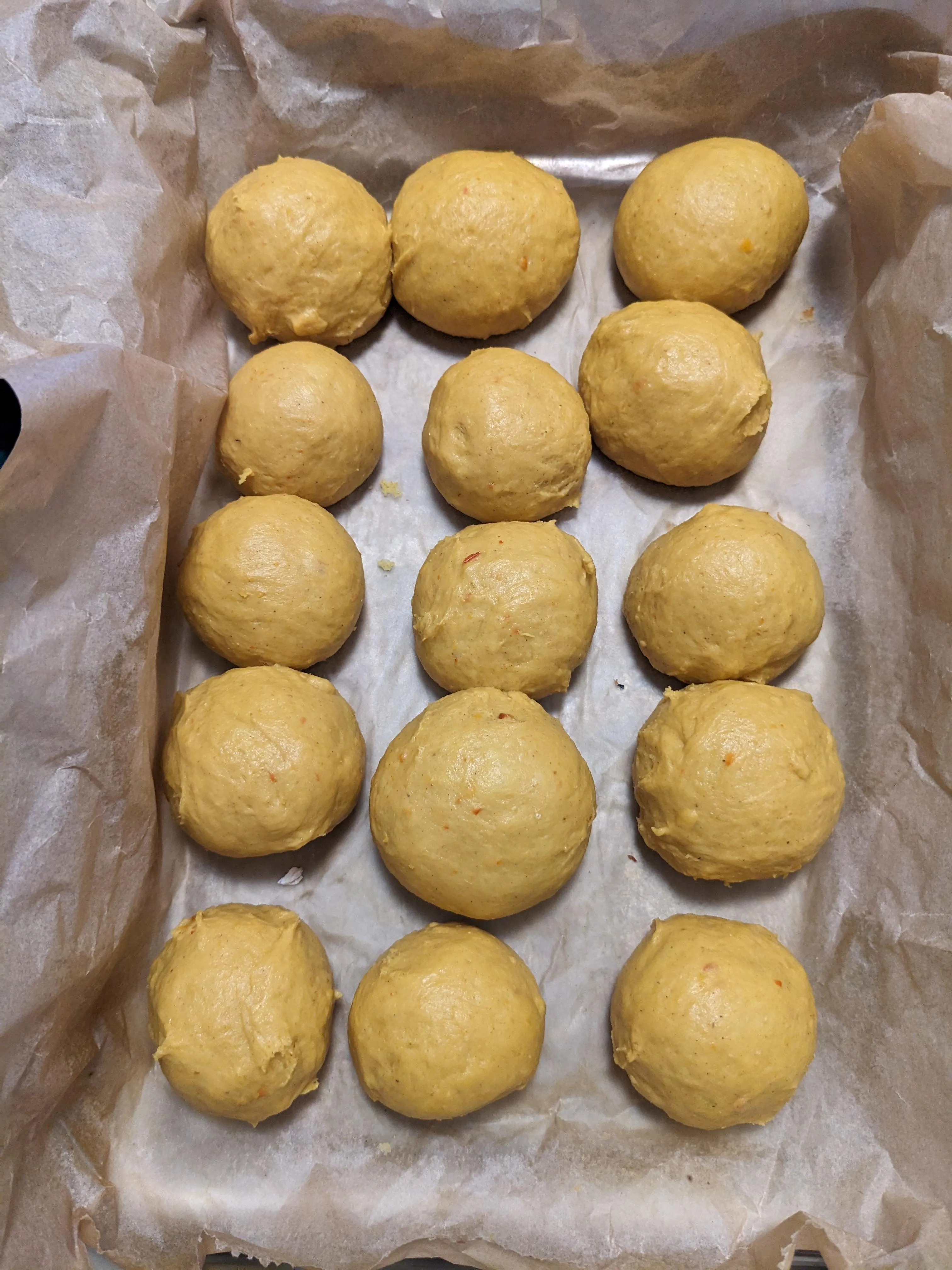 Fifteen dough balls in a baking dish, before the second rise